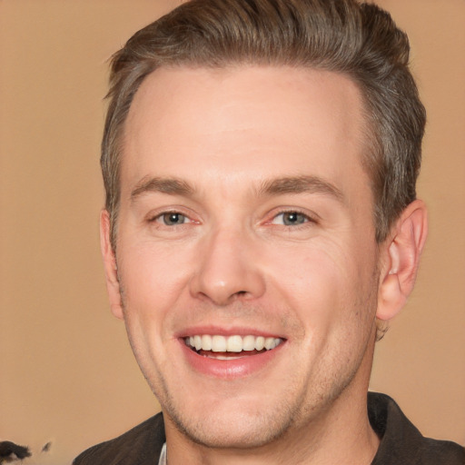 Joyful white adult male with short  brown hair and brown eyes