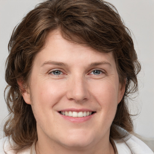 Joyful white young-adult female with medium  brown hair and blue eyes