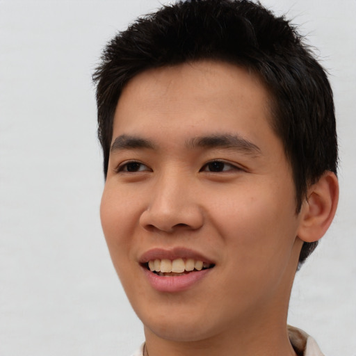 Joyful asian young-adult male with short  brown hair and brown eyes
