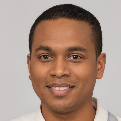 Joyful black young-adult male with short  black hair and brown eyes