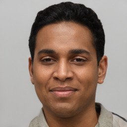 Joyful latino young-adult male with short  black hair and brown eyes