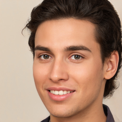 Joyful white young-adult male with medium  brown hair and brown eyes