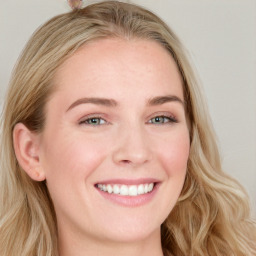 Joyful white young-adult female with long  brown hair and blue eyes