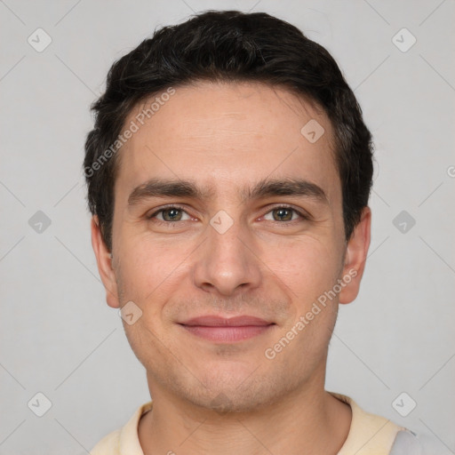 Joyful white young-adult male with short  black hair and brown eyes