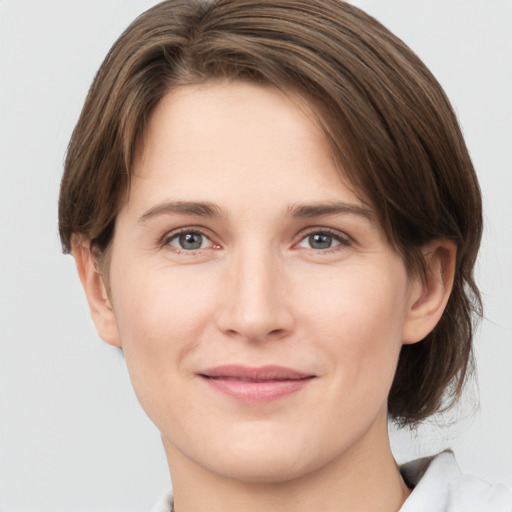 Joyful white young-adult female with medium  brown hair and grey eyes