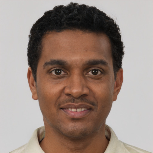 Joyful black young-adult male with short  black hair and brown eyes