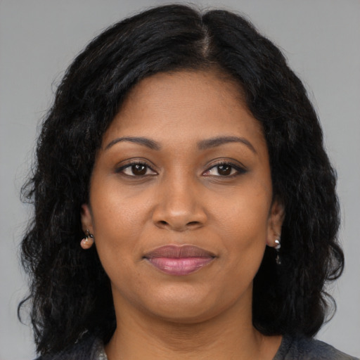 Joyful black young-adult female with long  brown hair and brown eyes