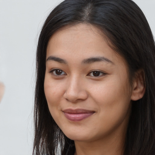 Joyful asian young-adult female with long  brown hair and brown eyes