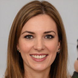 Joyful white young-adult female with long  brown hair and brown eyes