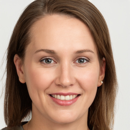 Joyful white young-adult female with long  brown hair and grey eyes