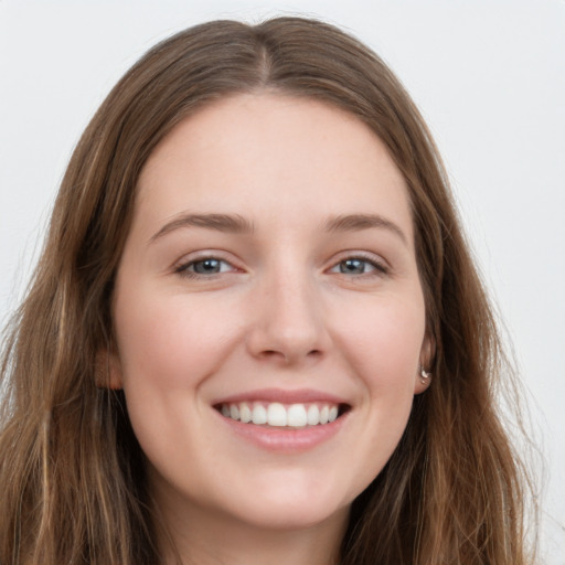 Joyful white young-adult female with long  brown hair and grey eyes