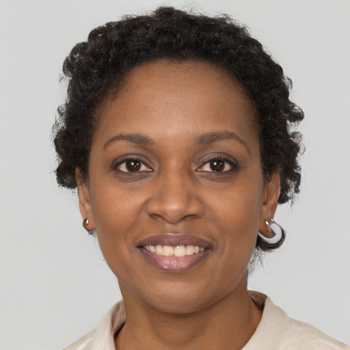 Joyful black young-adult female with short  brown hair and brown eyes