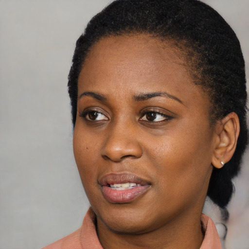 Joyful black young-adult female with short  black hair and brown eyes