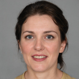 Joyful white adult female with medium  brown hair and blue eyes