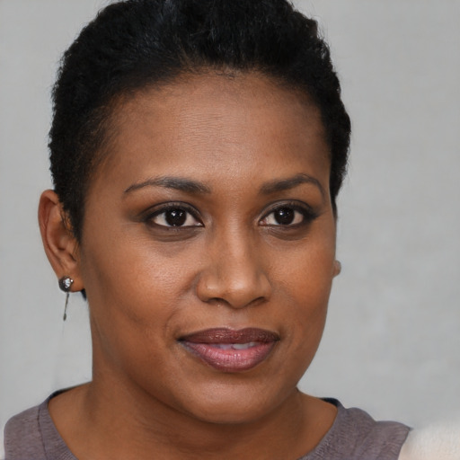 Joyful black young-adult female with short  brown hair and brown eyes