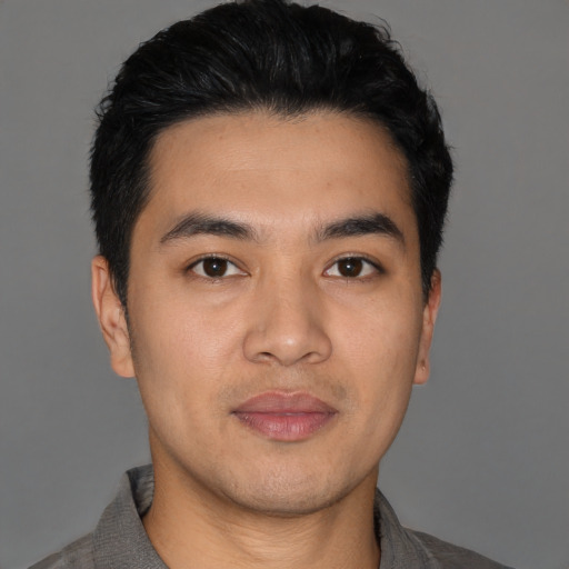 Joyful asian young-adult male with short  black hair and brown eyes