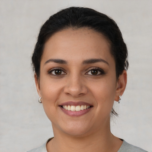 Joyful latino young-adult female with short  brown hair and brown eyes