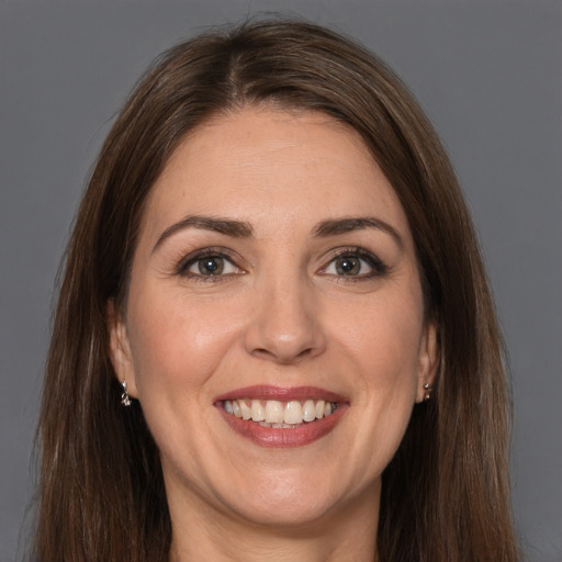 Joyful white adult female with long  brown hair and brown eyes