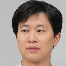 Joyful asian adult male with short  brown hair and brown eyes