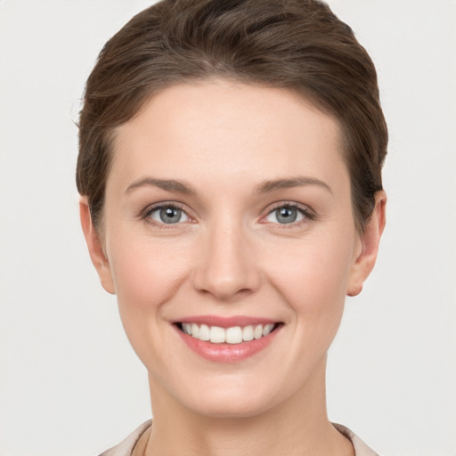 Joyful white young-adult female with short  brown hair and grey eyes