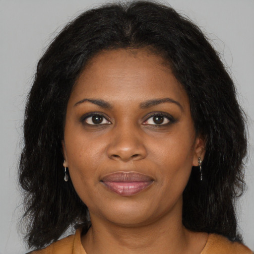 Joyful black young-adult female with long  brown hair and brown eyes