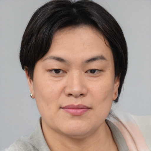 Joyful asian young-adult female with short  brown hair and brown eyes
