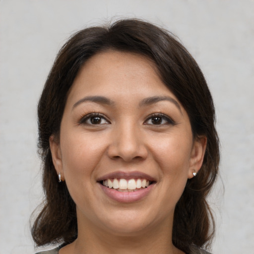 Joyful latino young-adult female with medium  brown hair and brown eyes