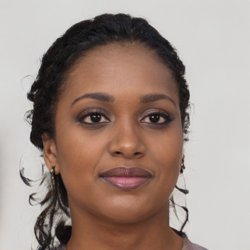 Joyful black young-adult female with long  brown hair and brown eyes