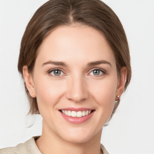 Joyful white young-adult female with medium  brown hair and grey eyes