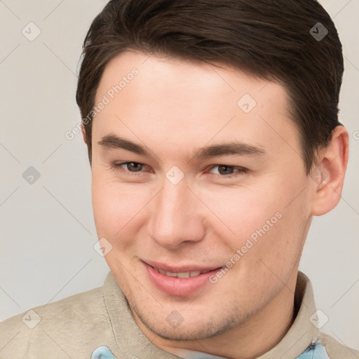 Joyful white young-adult male with short  brown hair and brown eyes