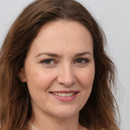 Joyful white young-adult female with long  brown hair and green eyes