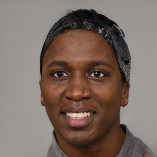 Joyful black young-adult male with short  black hair and brown eyes