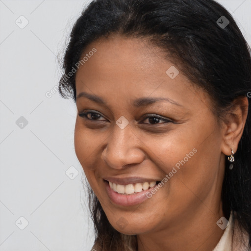 Joyful black young-adult female with long  brown hair and brown eyes