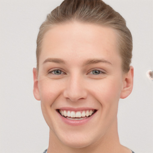 Joyful white young-adult female with short  brown hair and grey eyes