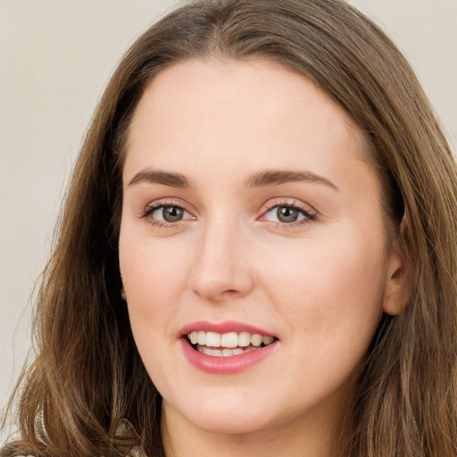 Joyful white young-adult female with long  brown hair and green eyes