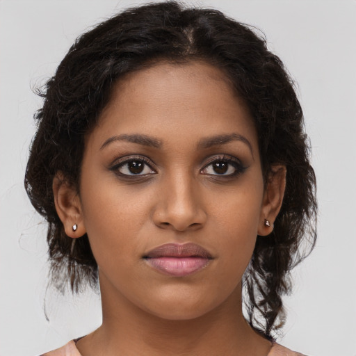 Joyful black young-adult female with long  brown hair and brown eyes