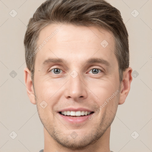 Joyful white young-adult male with short  brown hair and grey eyes