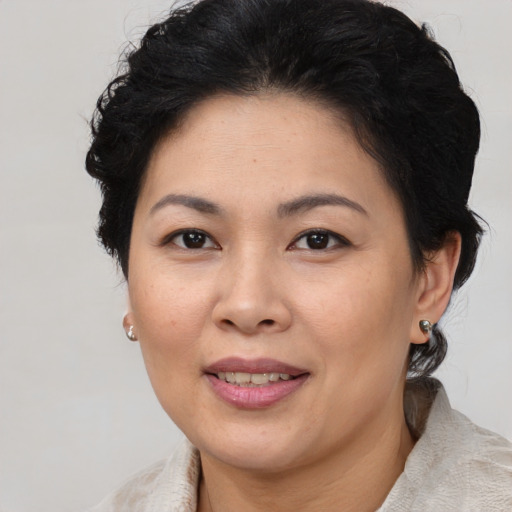 Joyful asian adult female with medium  brown hair and brown eyes