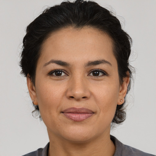 Joyful latino adult female with medium  brown hair and brown eyes