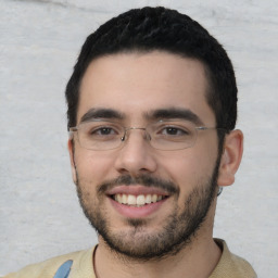 Joyful white young-adult male with short  black hair and brown eyes