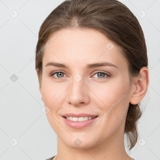 Joyful white young-adult female with medium  brown hair and grey eyes