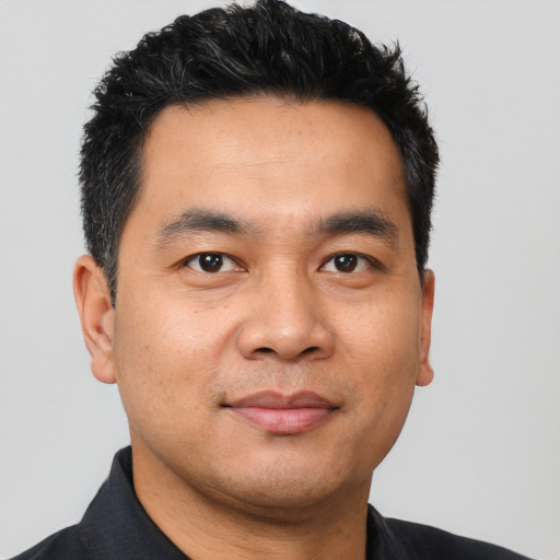 Joyful latino young-adult male with short  black hair and brown eyes