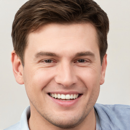 Joyful white young-adult male with short  brown hair and grey eyes