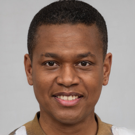 Joyful black young-adult male with short  brown hair and brown eyes