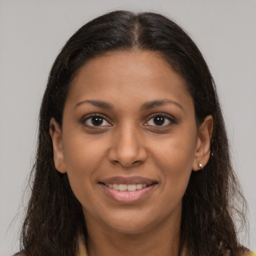 Joyful black young-adult female with long  brown hair and brown eyes