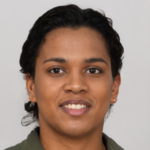 Joyful black young-adult female with short  black hair and brown eyes