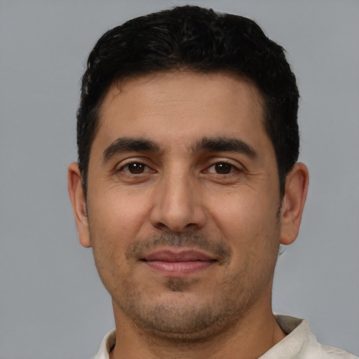 Joyful latino young-adult male with short  black hair and brown eyes