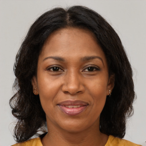Joyful black adult female with medium  brown hair and brown eyes