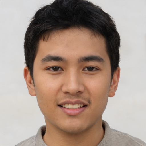 Joyful asian young-adult male with short  brown hair and brown eyes