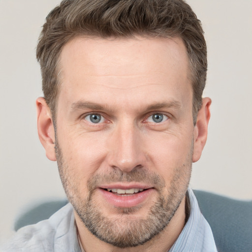 Joyful white adult male with short  brown hair and brown eyes